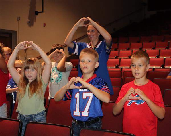 Students and Mrs. Corby participating in assembly