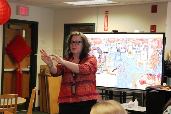Mrs. Penn demonstrates how to use chopsticks