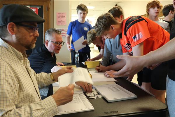 Signing for their ballots.