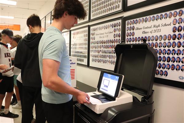 Student puts ballot in machine