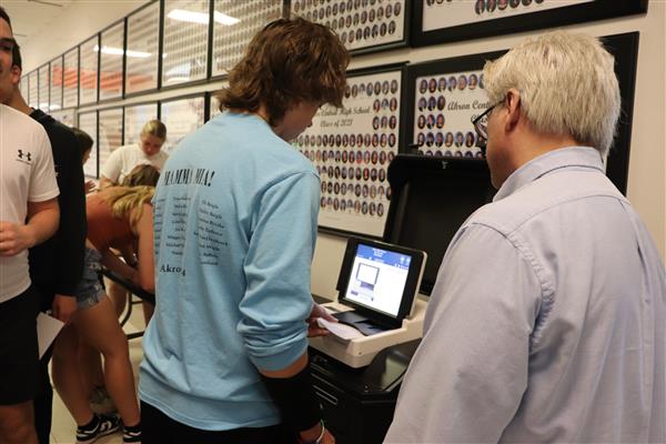 Board of Elections rep helps student with ballot